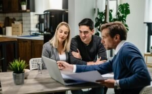 Real estate agent discussing property purchase documents with buyers inside a modern house in Brazil.